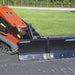 mini skid steer snow plow in field