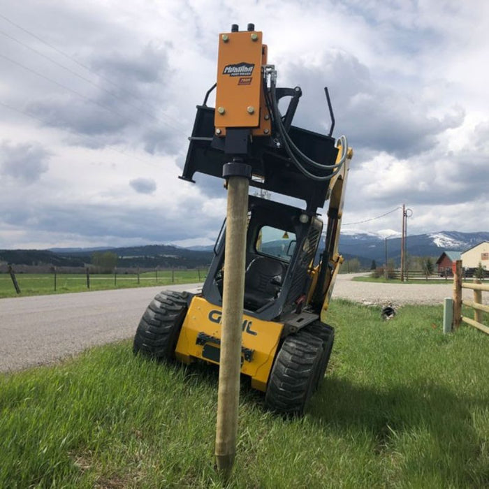 montana post driver on a ditch driving wooden post front view