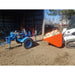 snow bucket skid steer side view loaded with wood from wood splitter